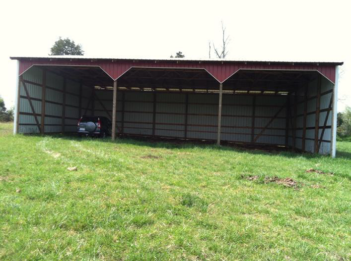 empty tractor shed with grass in front of it